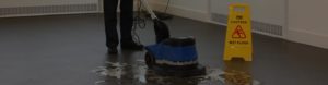 a man performing floor deep cleaning services using a floor buffer to clean a community centre floor.