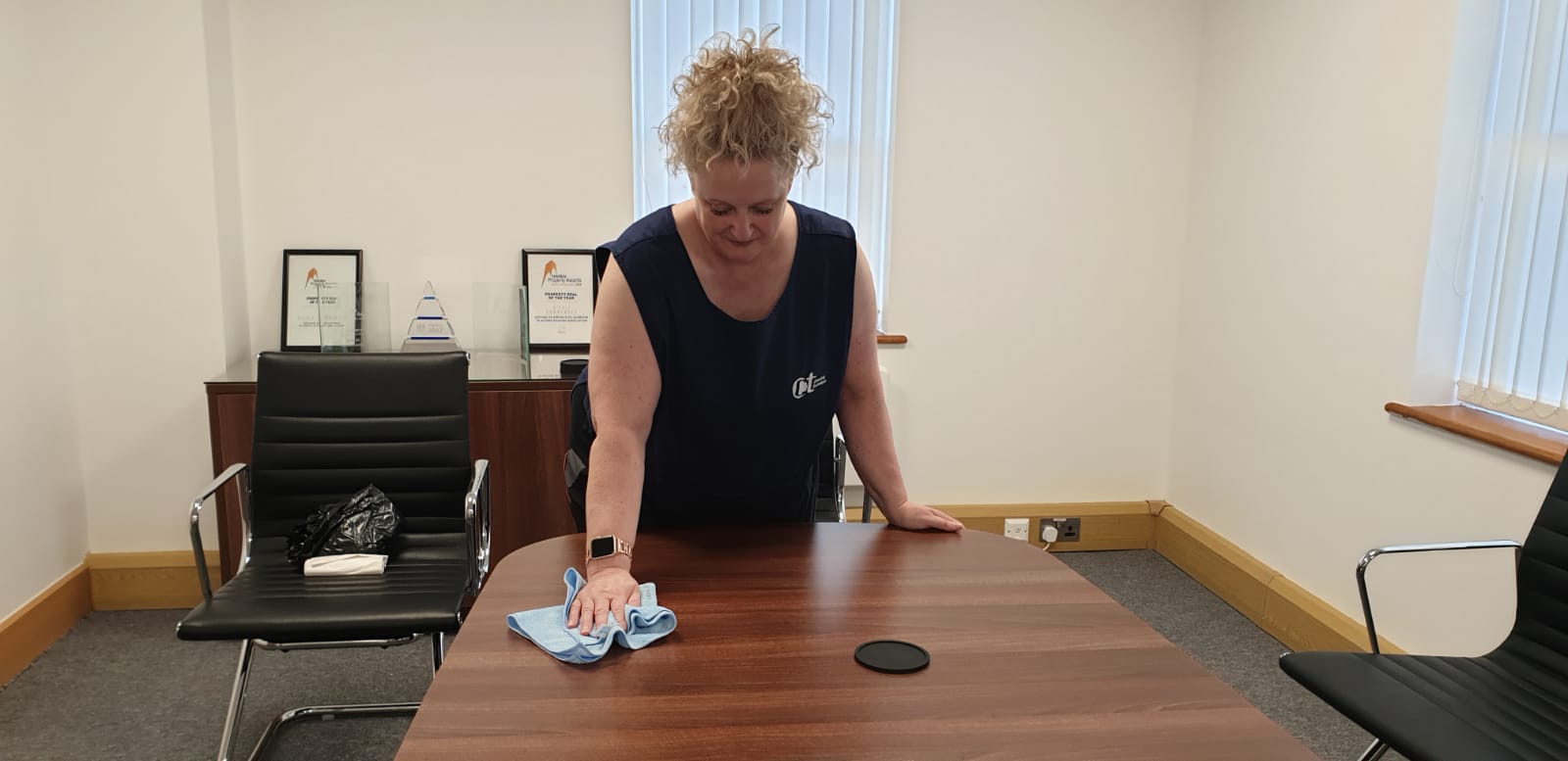 office cleaner wiping conference table