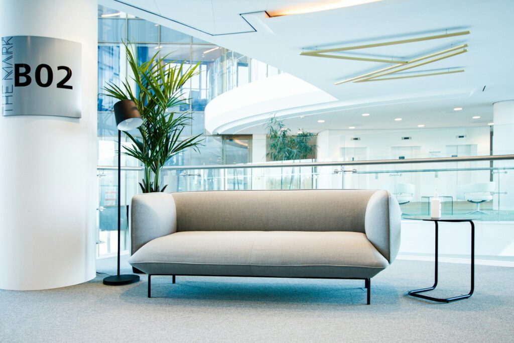 A grey sofa on an office balcony that overlooks a reception.