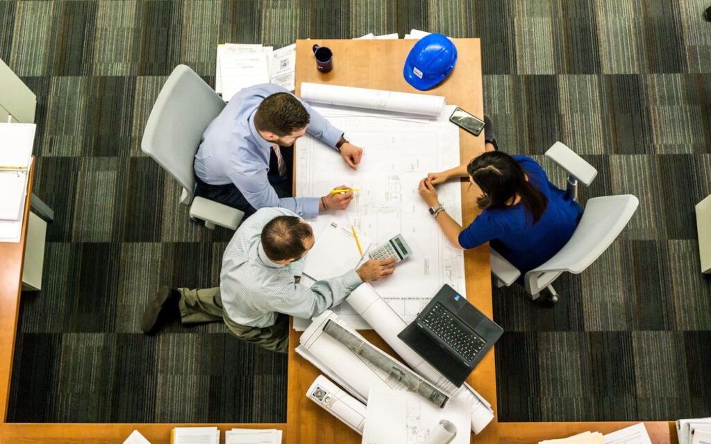 a bird's eye view of employees sitting around a cluttered desk